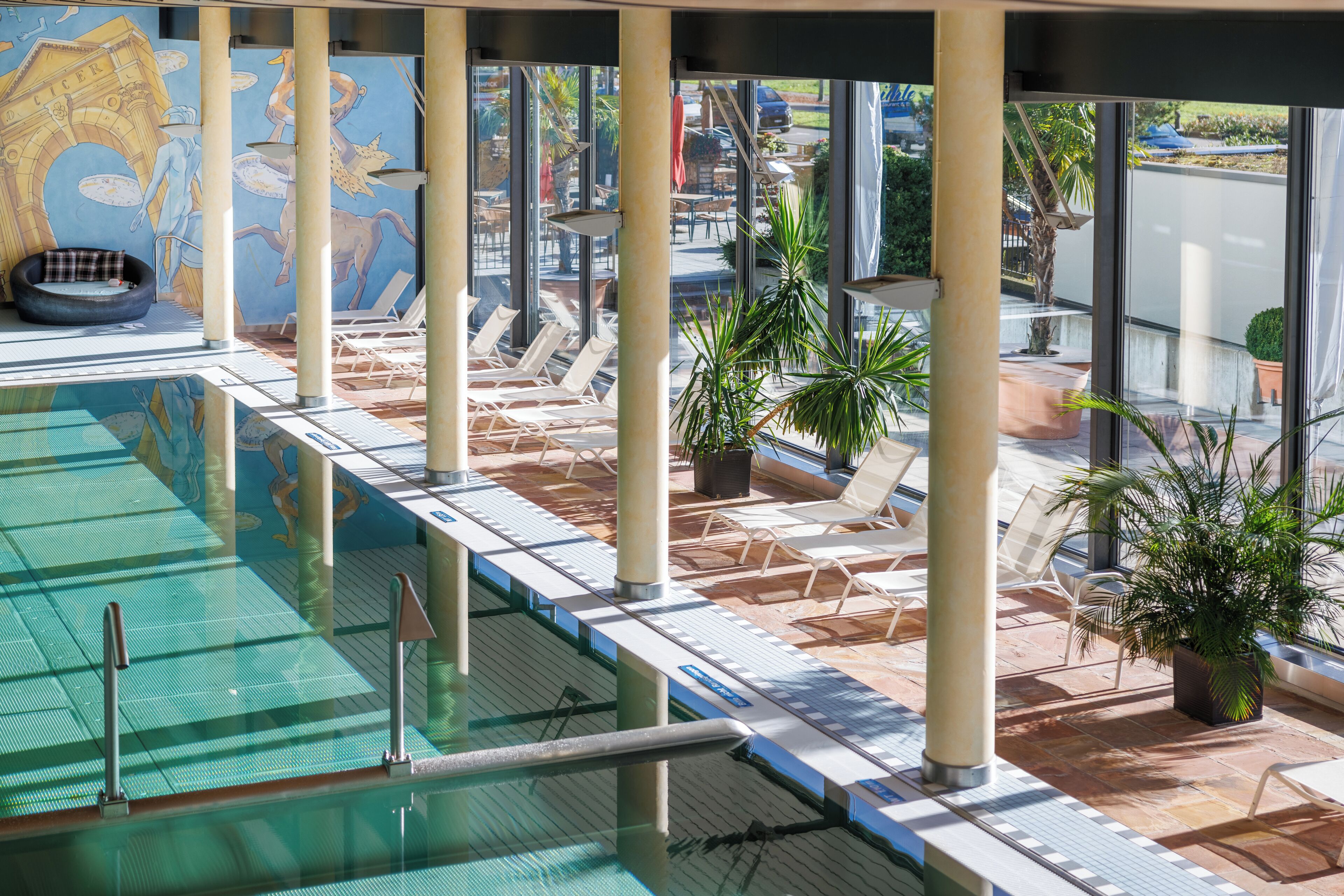 A pool area with lounge chairs and potted plants.