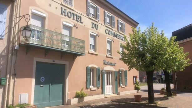 Un edificio con un letrero que dice "HOTEL DU COMMERCI" y un letrero de "Restaurante" debajo.