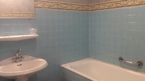 Un baño con lavamanos, bañera e inodoro.