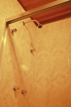 A shower with a metal frame and a handheld showerhead.