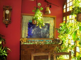 Una habitación con un aparador de madera, un reloj en la pared y una ventana que ofrece vistas a una noche estrellada.