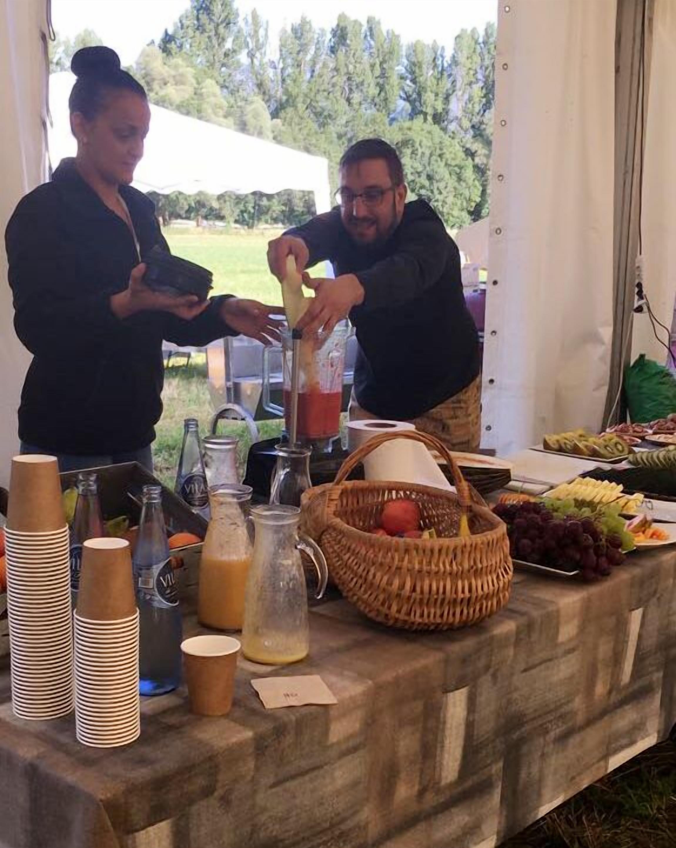 Montaje de bufé con estación de bebidas, comida y una cesta de mimbre.