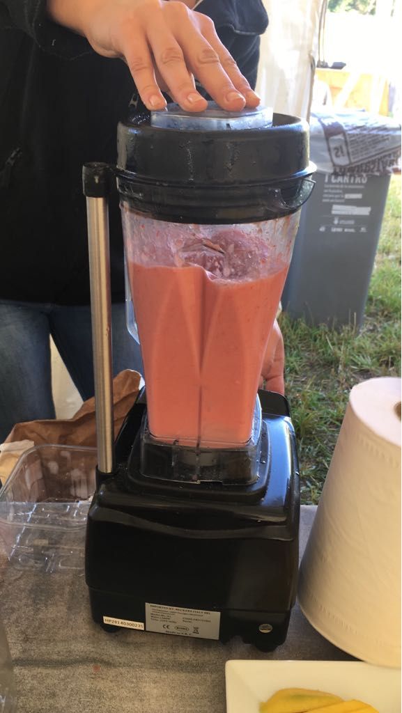 A person operating a blender outdoors.