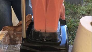 A person operating a blender outdoors.