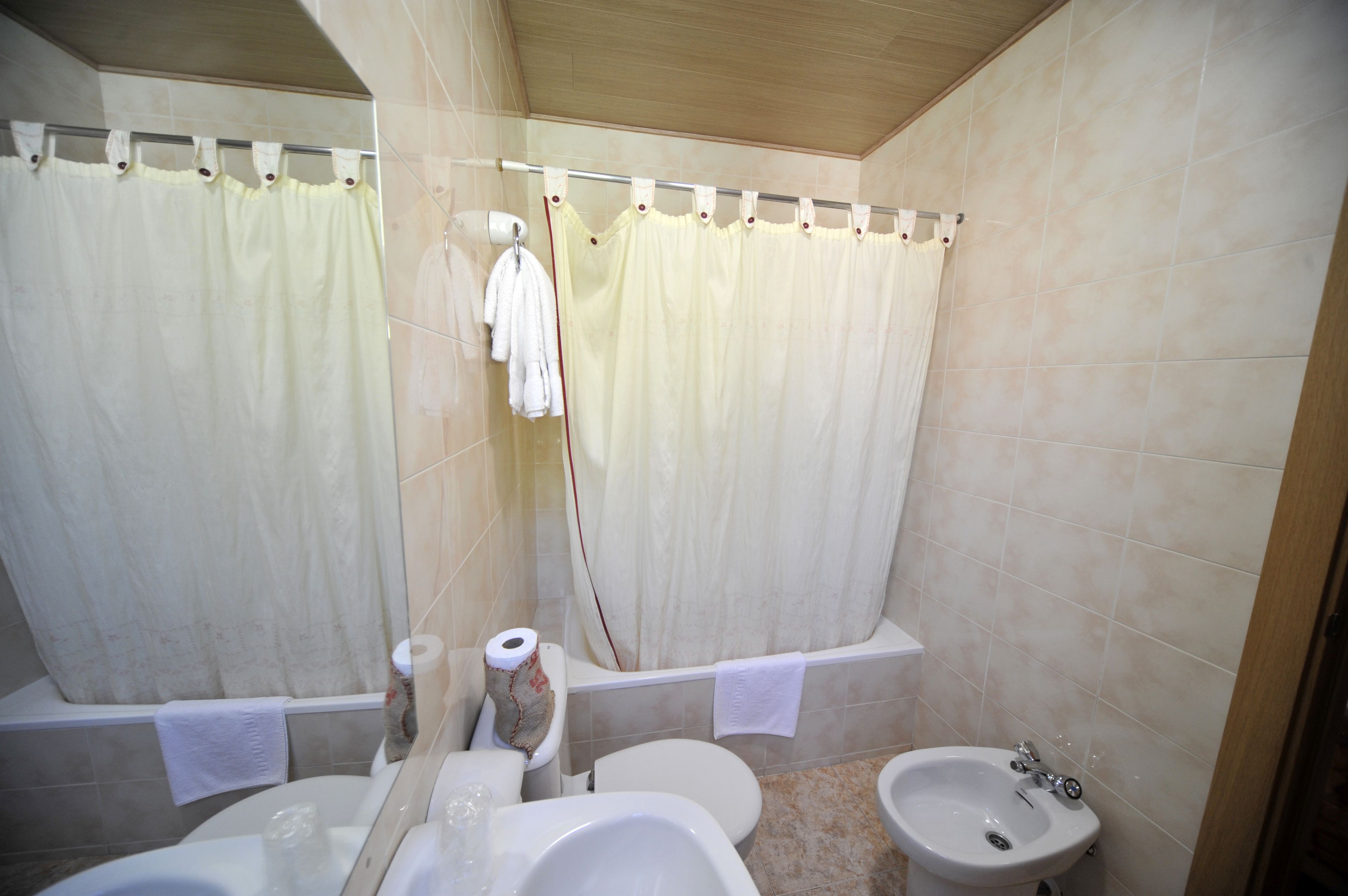 A bathroom with a bathtub, toilet, bidet, and sink.