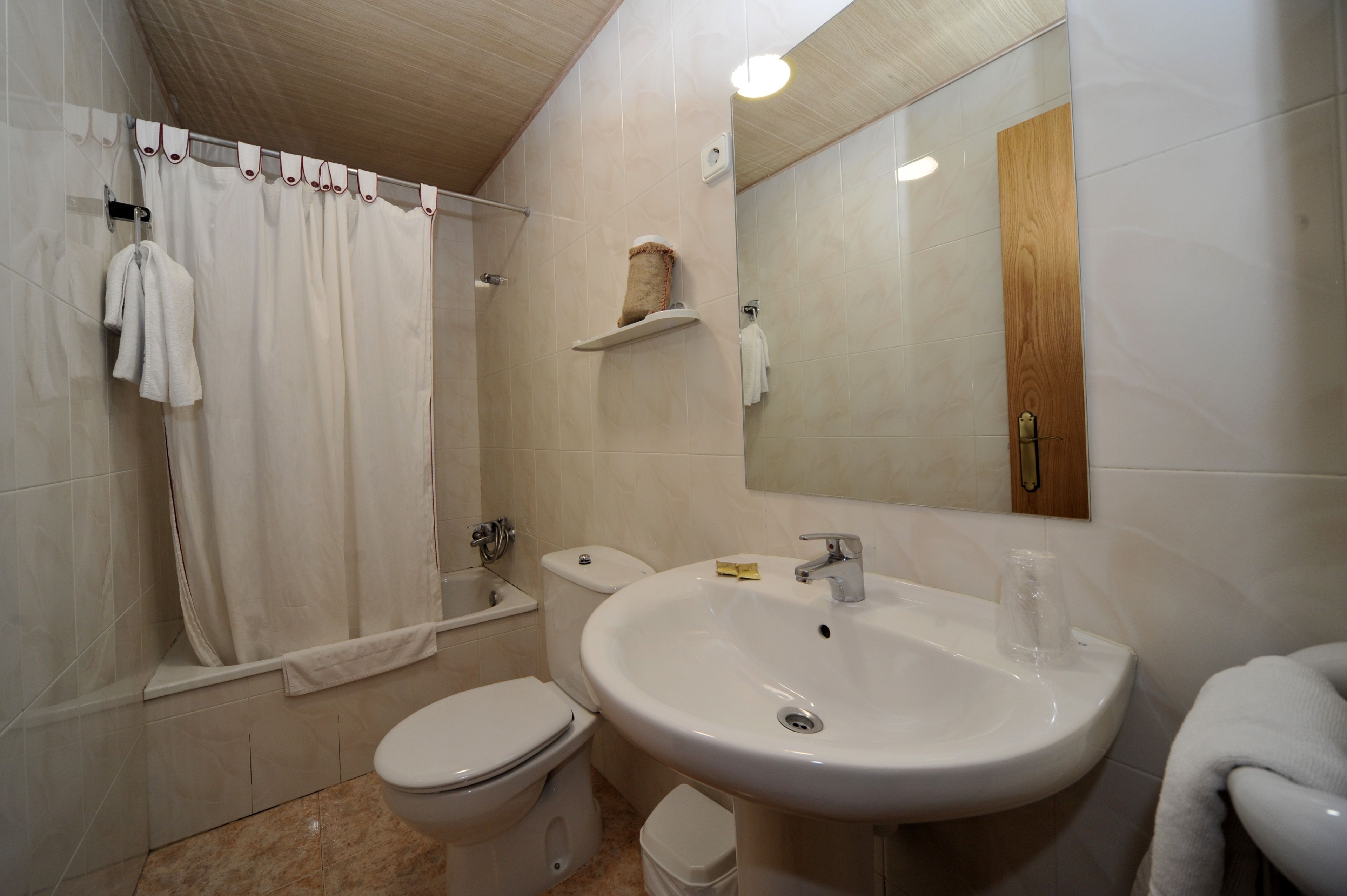 Un baño con inodoro, lavamanos y ducha.