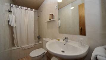 Un baño con inodoro, lavamanos y ducha.