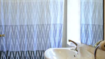 Un baño con inodoro, lavamanos y cortina de ducha.