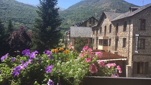 A stone building with a sign indicating it is a hostel. - Hotel Vall d'Aneu (Esterri D'Aneu)
