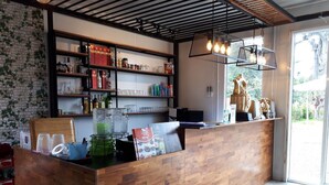 Una reception con piano in legno, una vetrina in vetro e scaffali con diversi oggetti.