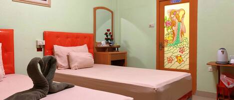 A hotel room with two beds, a mirror, a painting, and a door with a floral design.