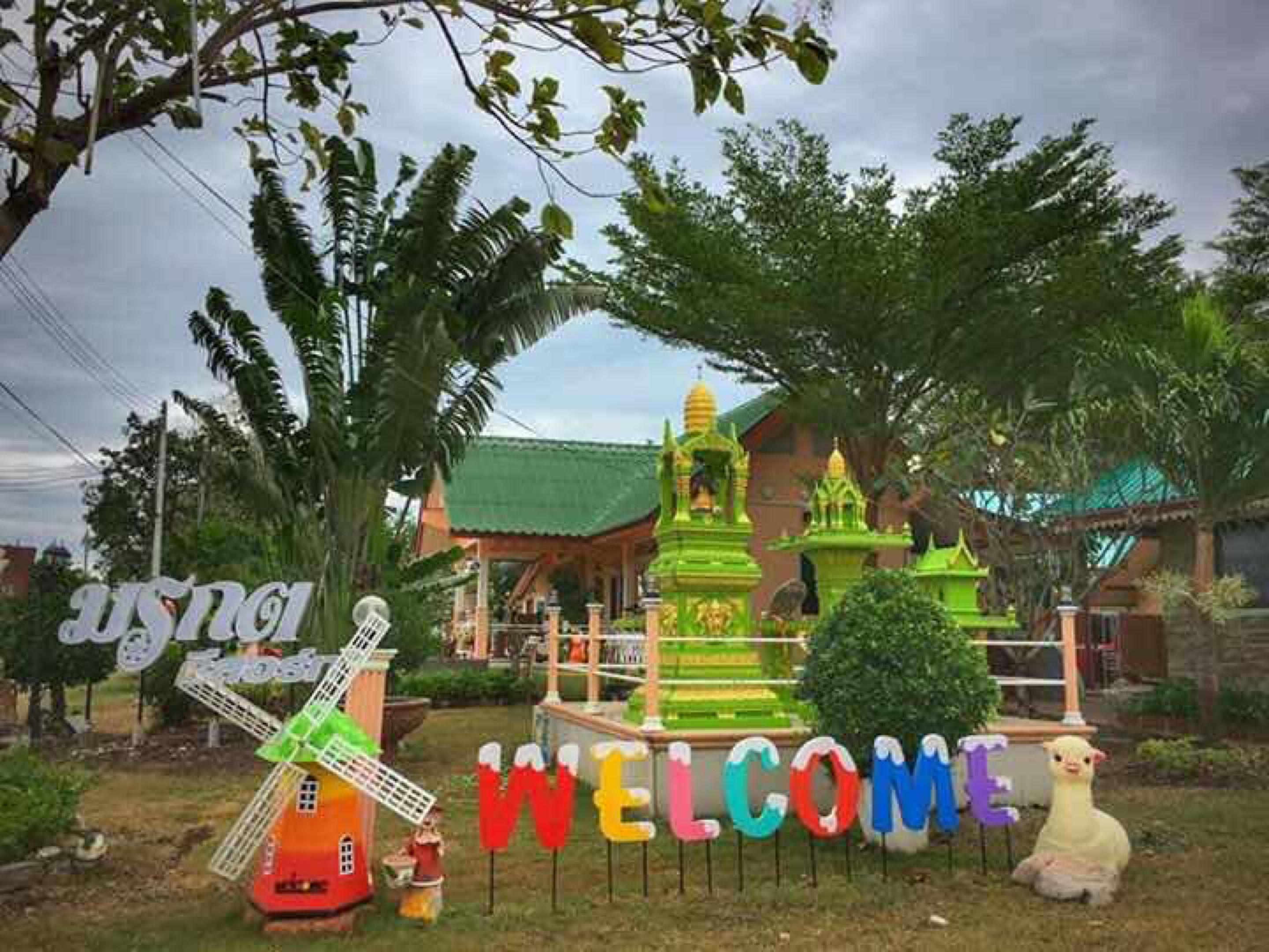 A colorful welcome sign with a windmill and a llama.