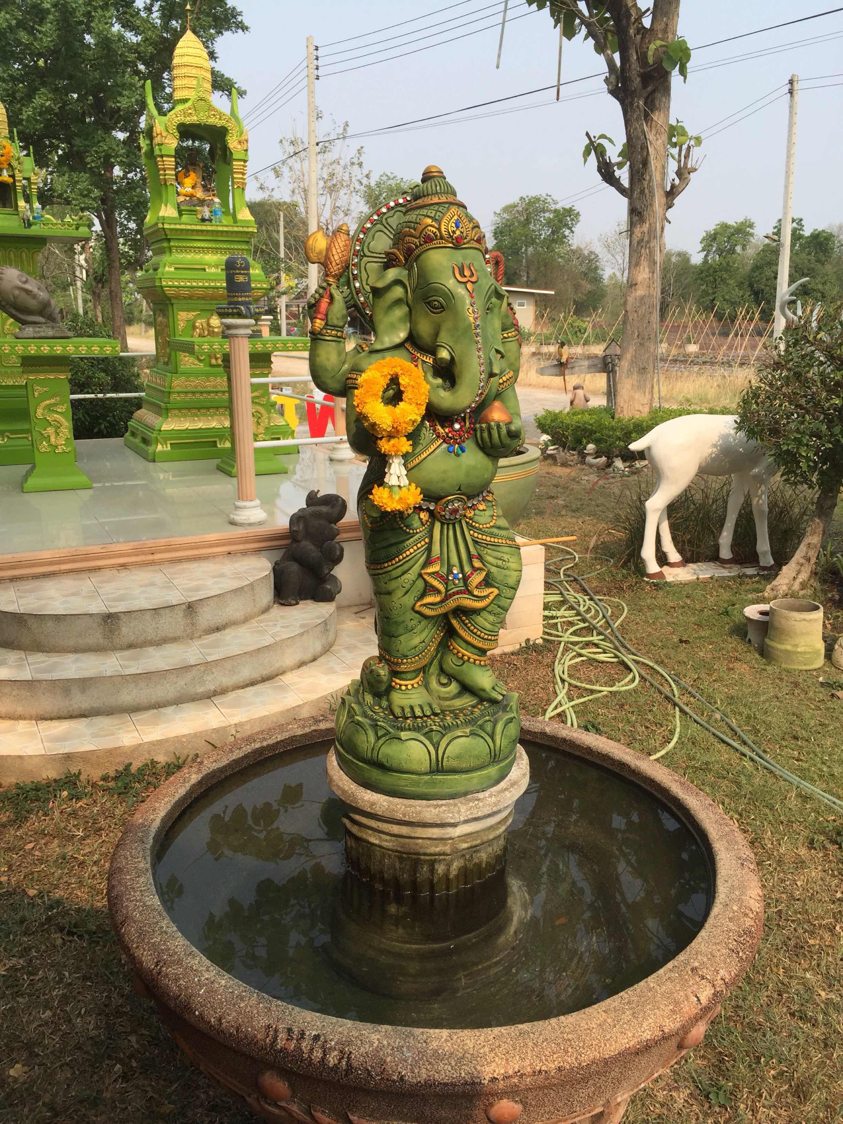 En statue af en guddom i en tempel, med et bassin foran.
