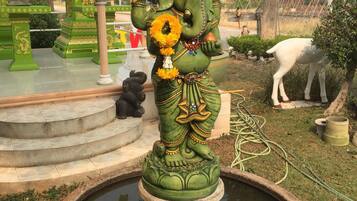 En statue af en guddom i en tempel, med et bassin foran.