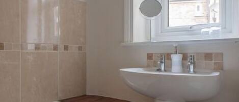 A bathroom with a bathtub, a sink, and a window.