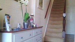 A staircase with a wooden handrail and beige carpet, leading to an upper floor. - Gyves Guest House (Eastbourne)