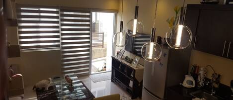A modern kitchen with a glass-top island, stainless steel appliances, and a sliding glass door to the patio.