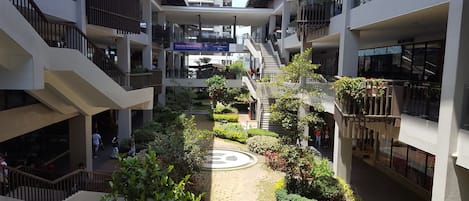 Un atrium à plusieurs niveaux, doté d’un jardin central, de balcons et de boutiques.