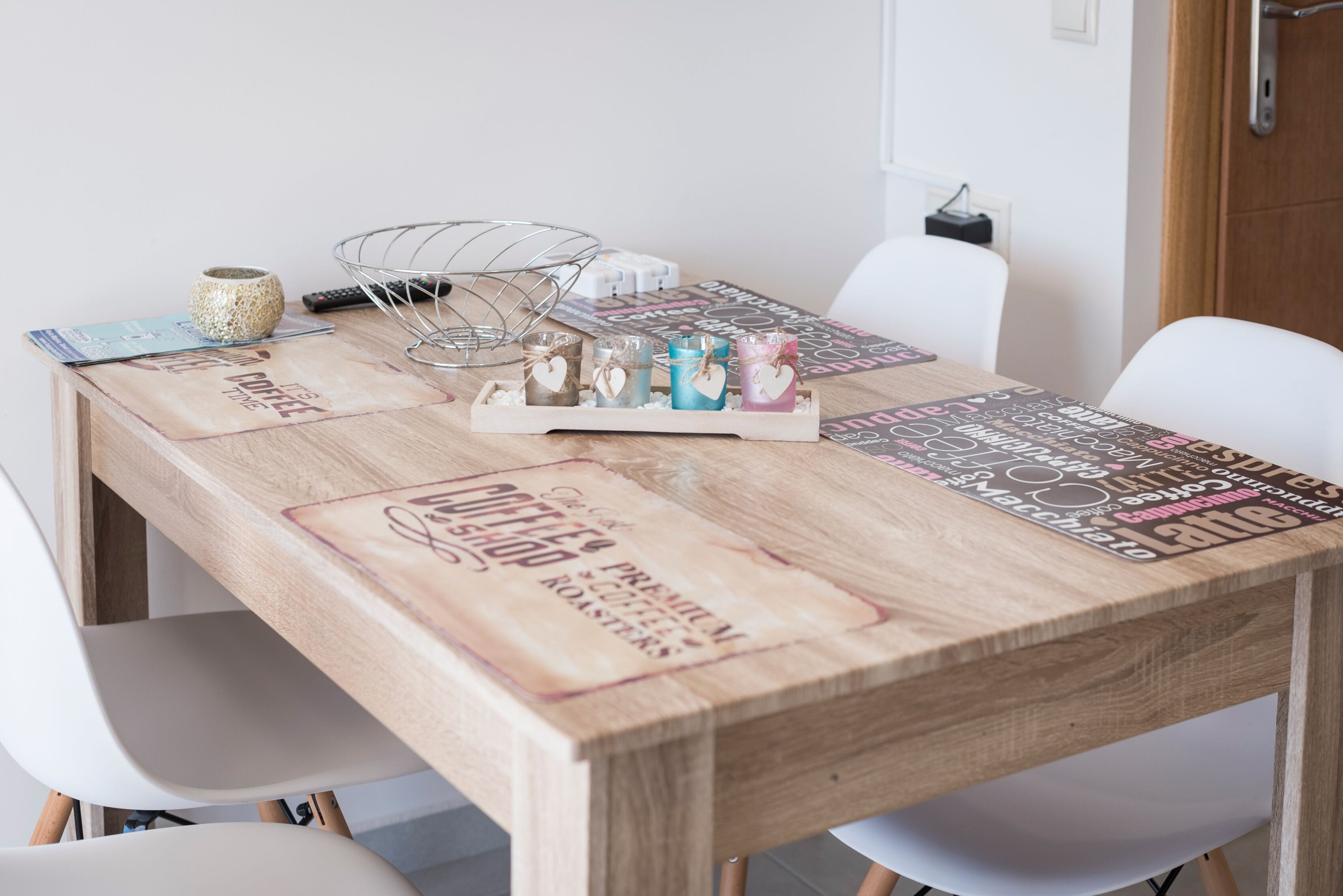 A wooden coffee shop table with a coffee shop theme, including a coffee cup and a menu.