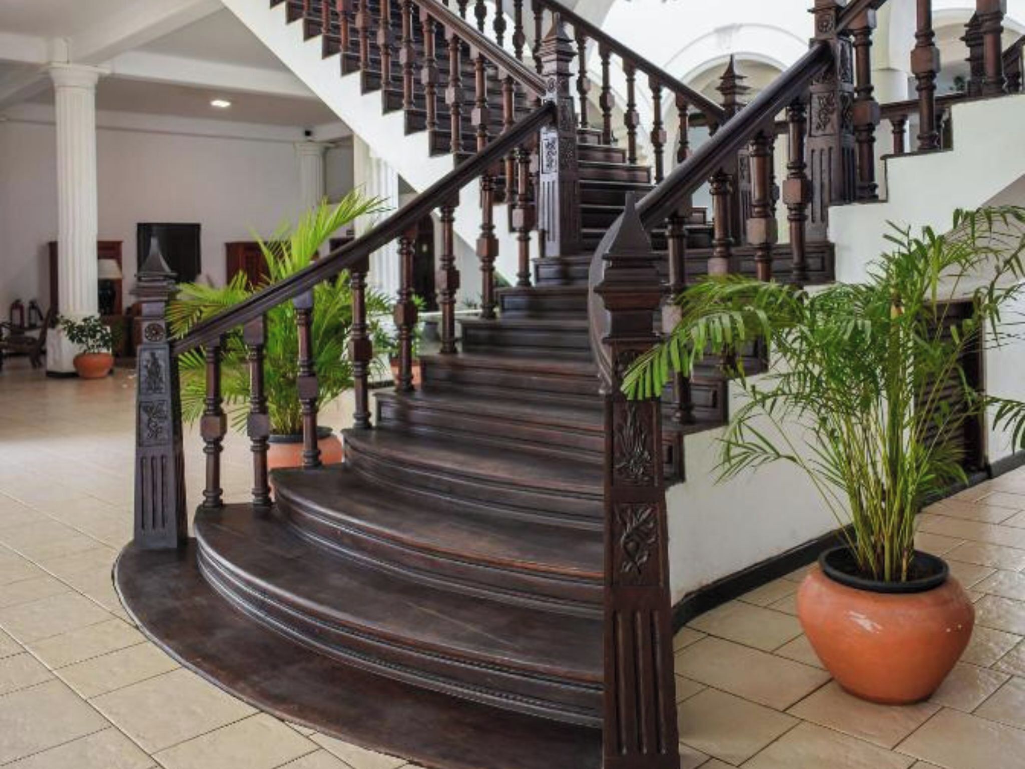 A grand staircase with dark wooden balusters and steps, leading to an upper floor.
