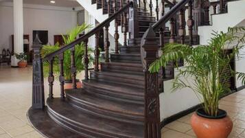 A grand staircase with dark wooden balusters and steps, leading to an upper floor.