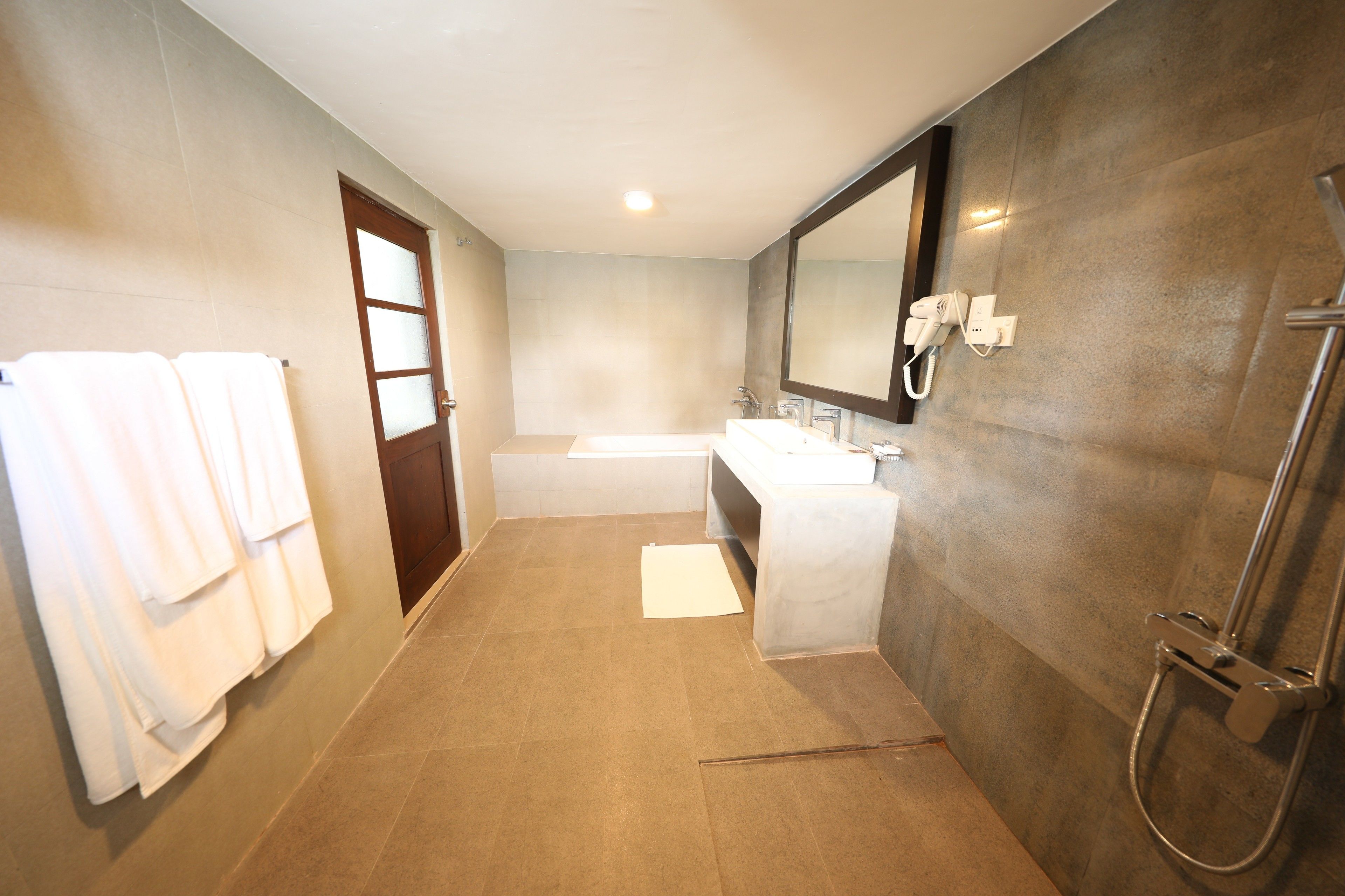 Une salle de bain moderne avec un grand miroir, une baignoire et une douche.
