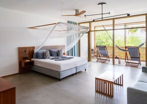 Un dormitorio moderno con una cama grande, cabecera de madera, mesita de noche y un balcón con sillas.
