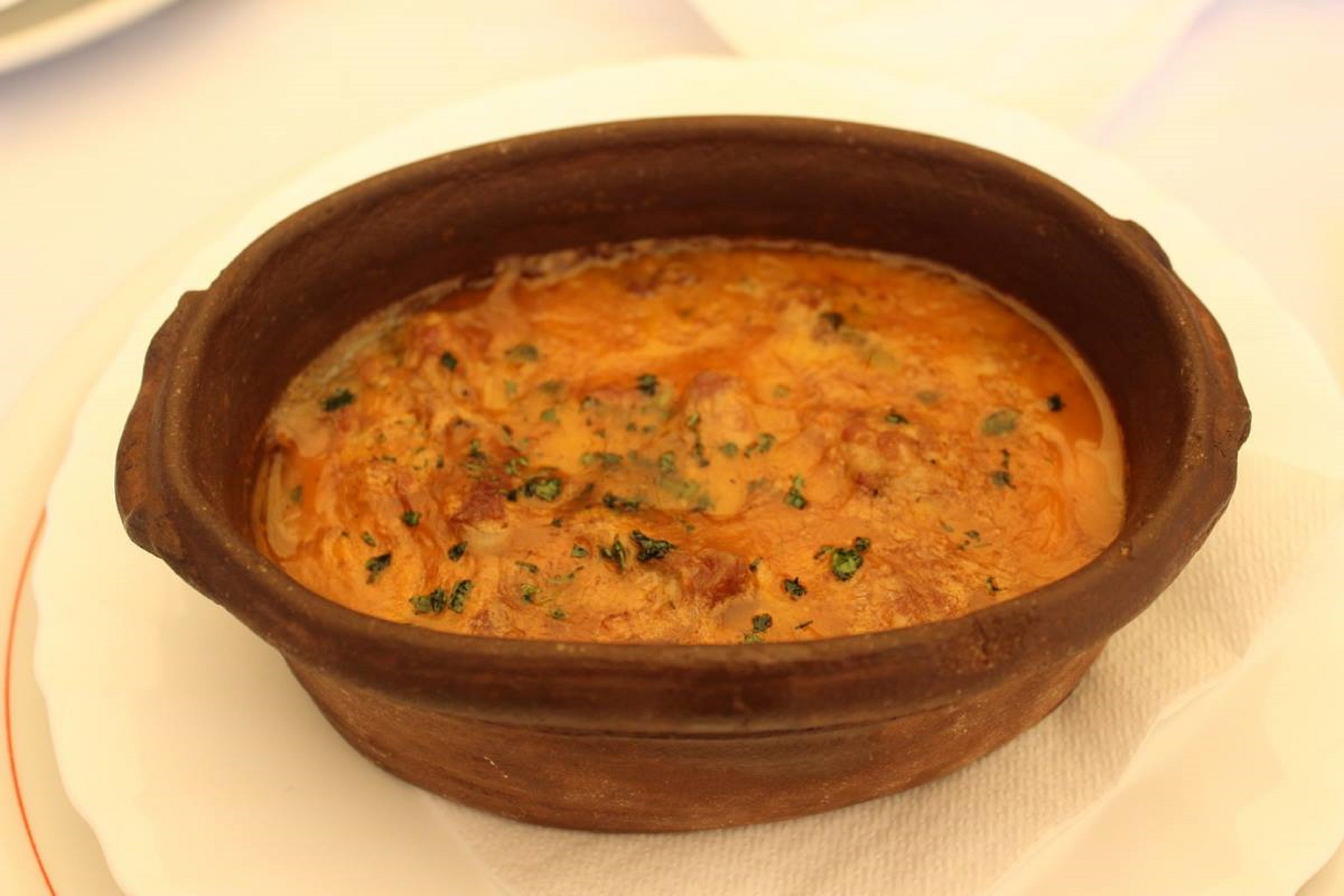 Una terracotta con un piatto guarnito di erbe aromatiche.