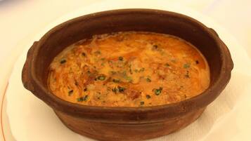 Una terracotta con un piatto guarnito di erbe aromatiche.