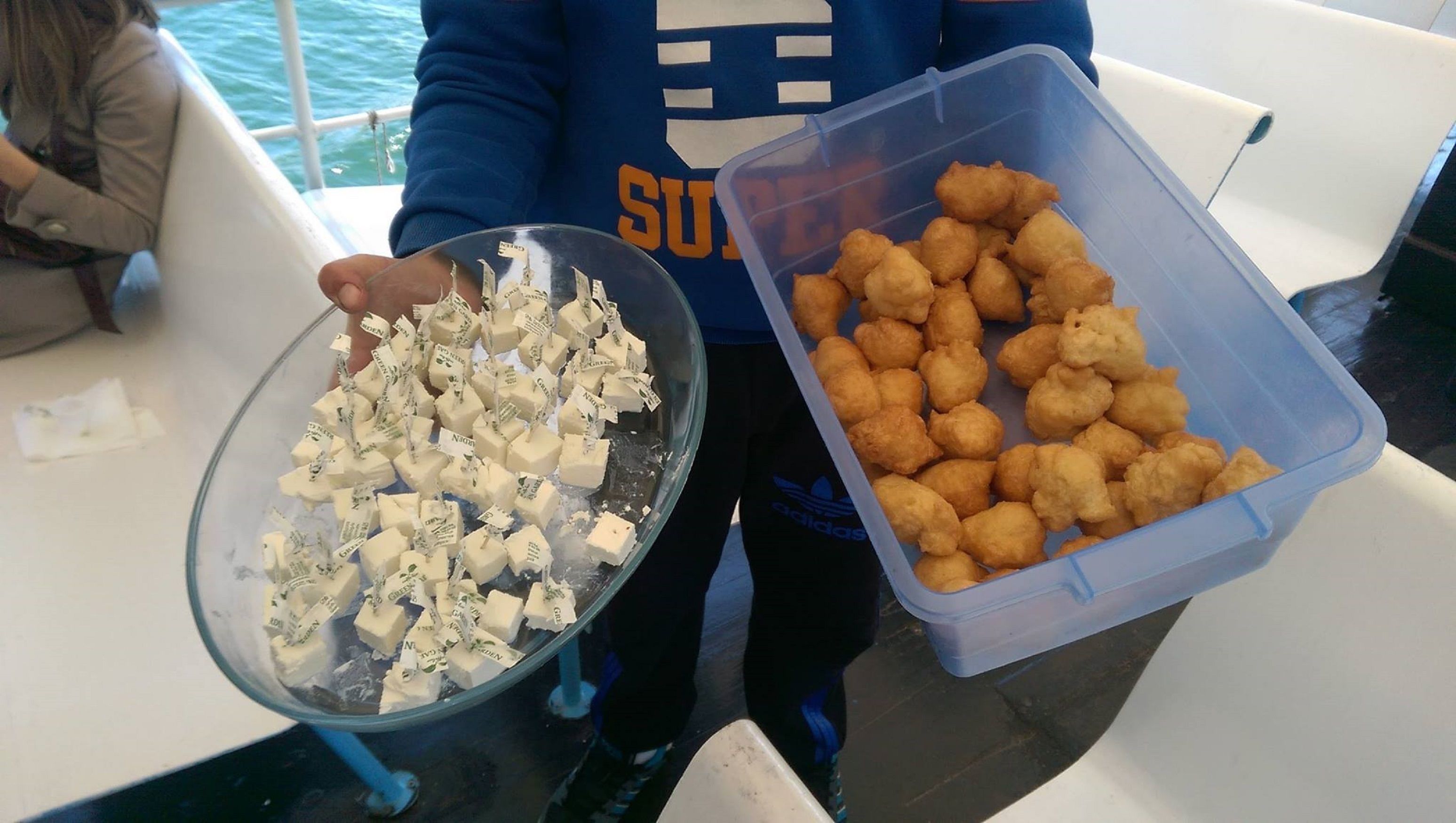 Una persona sosté un bol de gelat i un envasament d'aperitius fregits.
