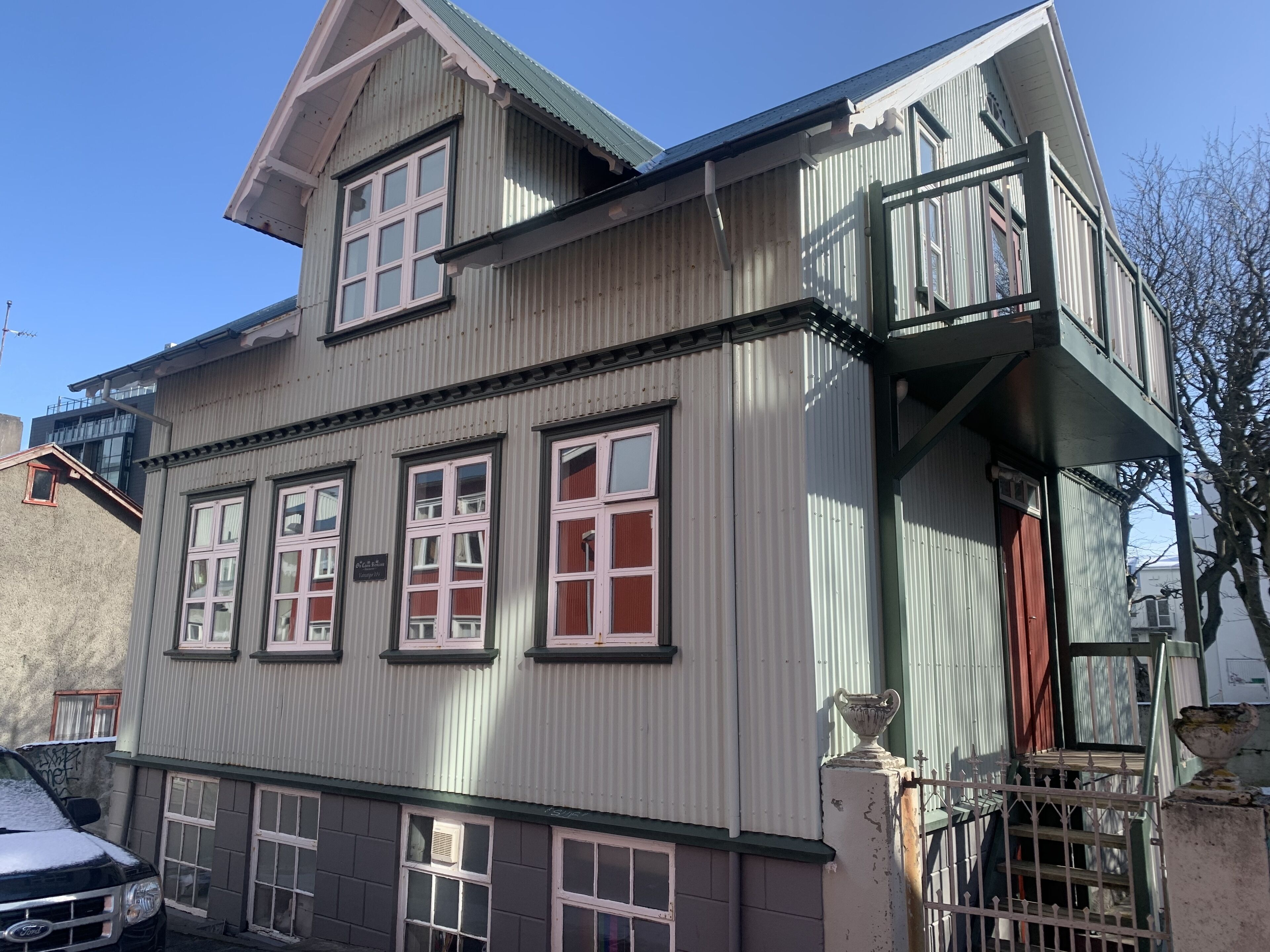 En byggnad med flera våningar, ett sadeltak, flera fönster och en synlig garageuppfart.