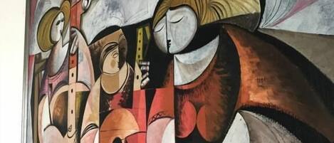A framed artwork with abstract figures and geometric shapes.