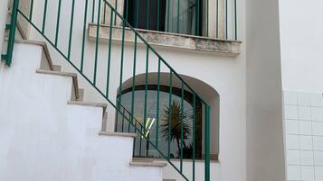 Una escalera con barandillas verdes que lleva a un rellano con una ventana.