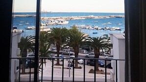 Un balcón con vista a un puerto deportivo y al mar.
