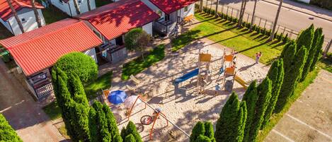 A residential area with houses, a playground, and a parking area.