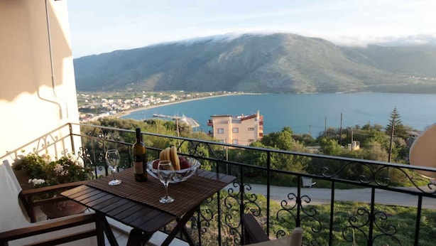 A balcony with a table, a bottle, and a glass.