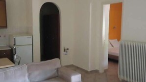 A compact living space with a kitchenette, a sofa, and a bed.