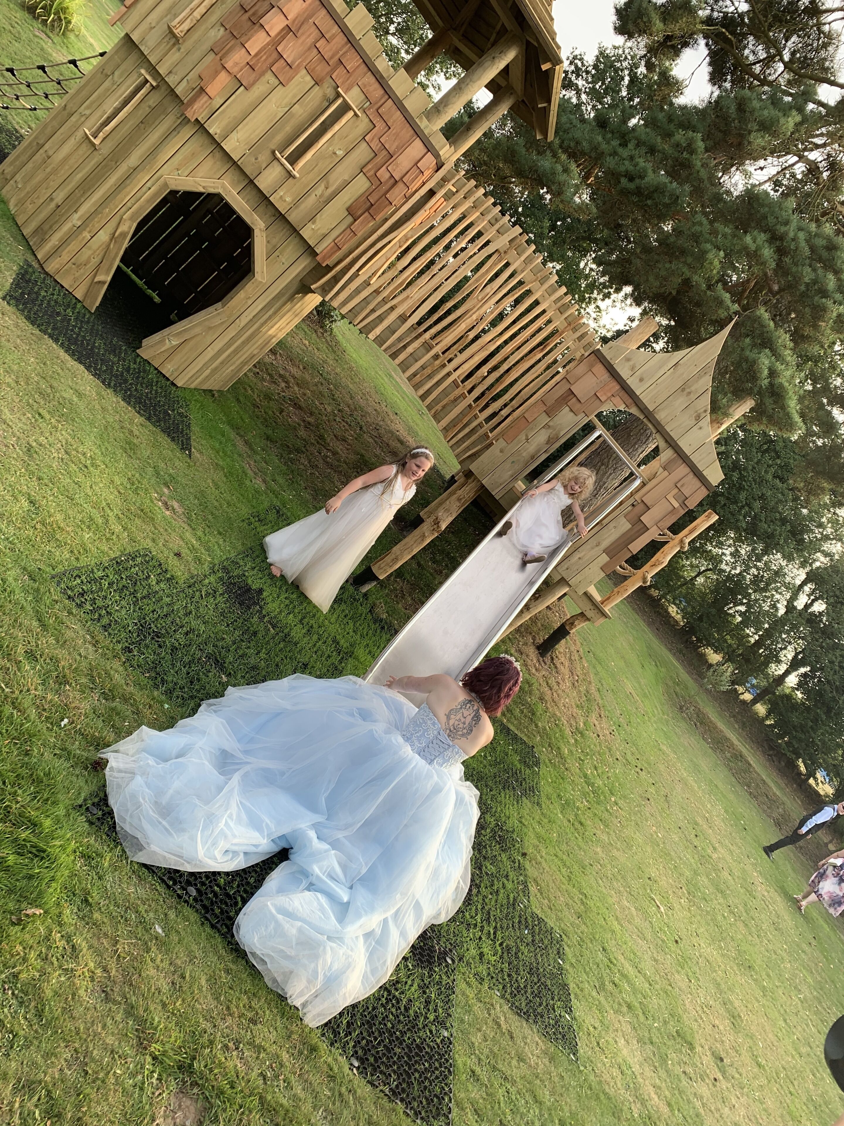 Eine Hochzeitsszene mit einer Holzkonstruktion im Hintergrund.
