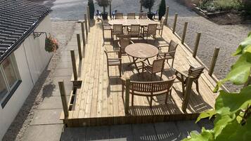 A wooden deck with outdoor seating and potted plants.