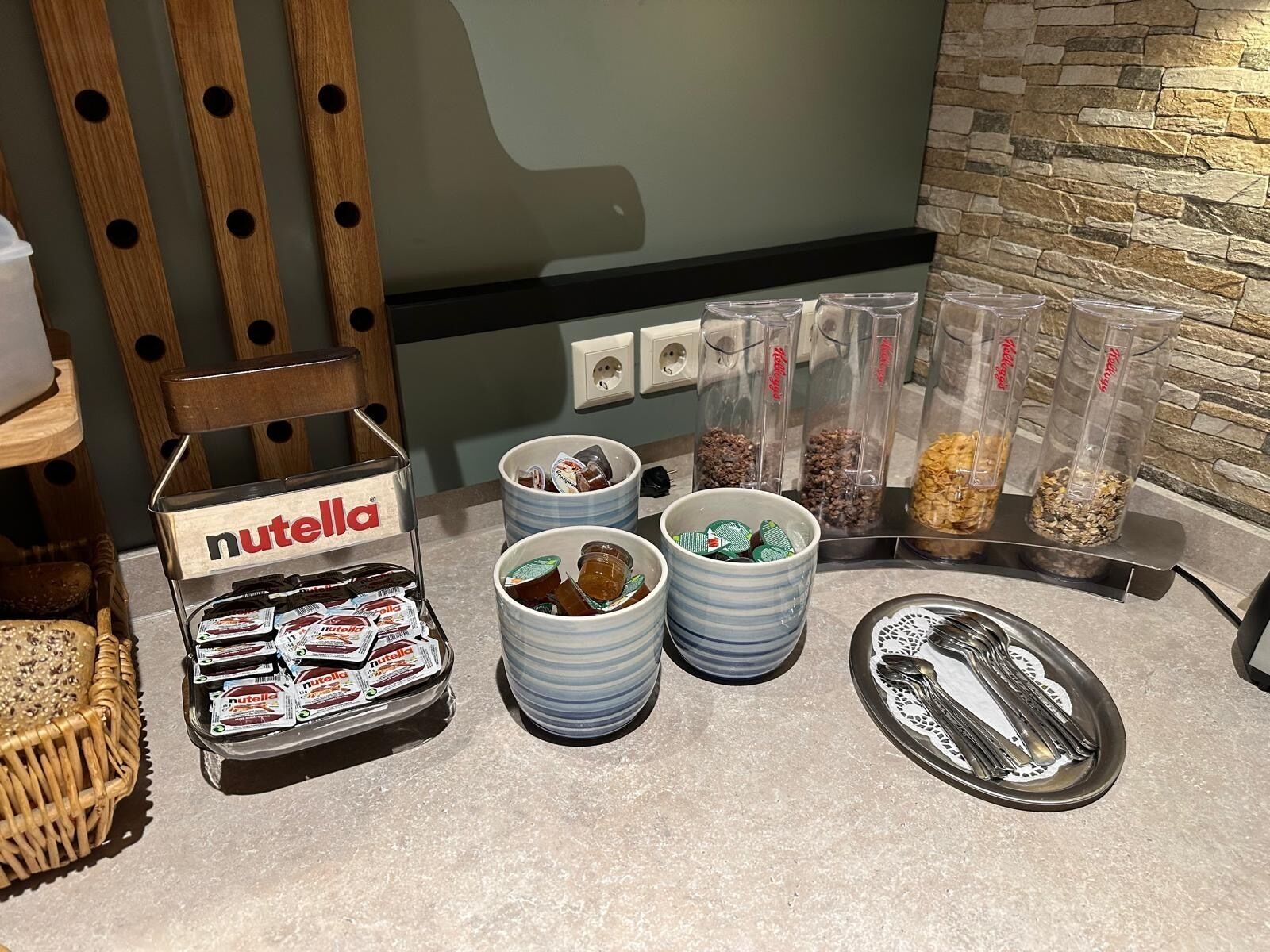 Un'area buffet con barattoli di Nutella, diversi cibi e utensili.