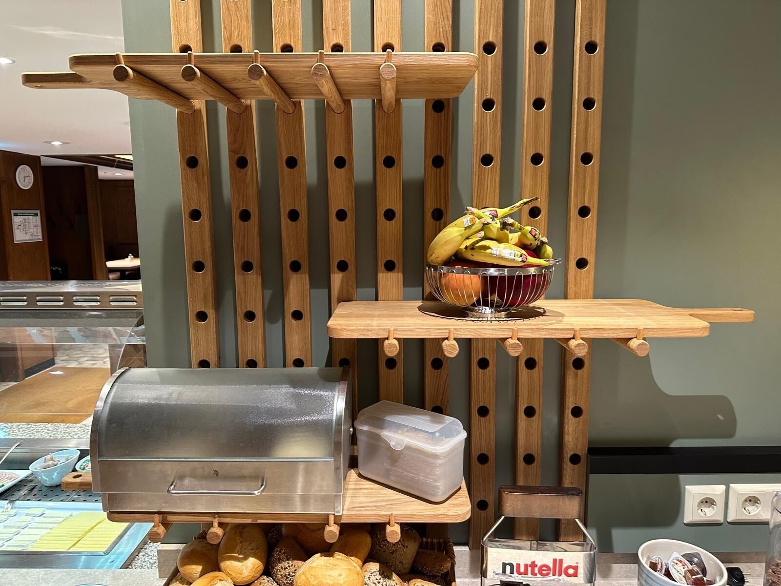 Uma área de cozinha com uma churrasqueira, uma tigela de frutas e um pote de Nutella.