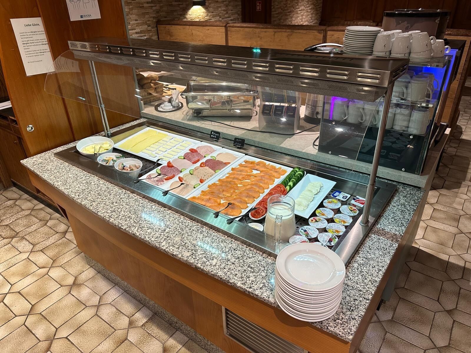 Mostrador de buffet con diferentes opciones de comida y una estación de café.