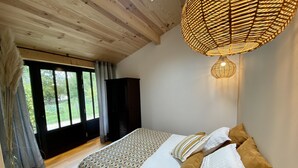 Une chambre à coucher avec un lit, une armoire et une grande fenêtre.