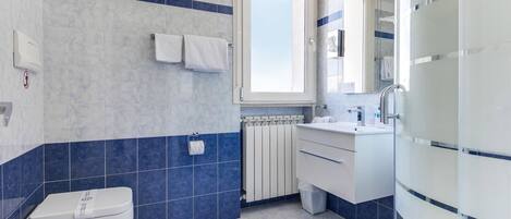 A modern bathroom with a toilet, sink, and shower.