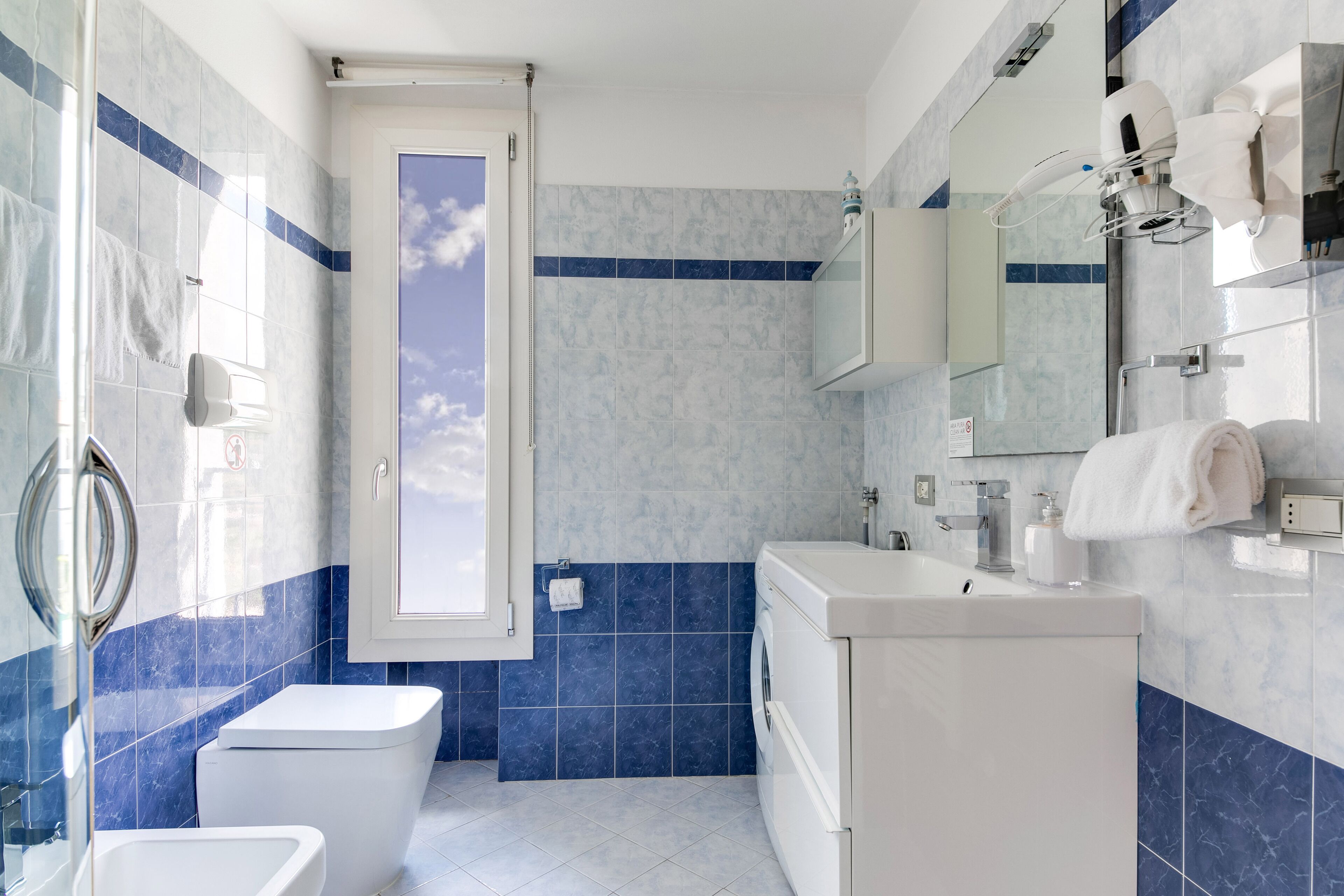 A modern bathroom with a toilet, sink, and mirror.