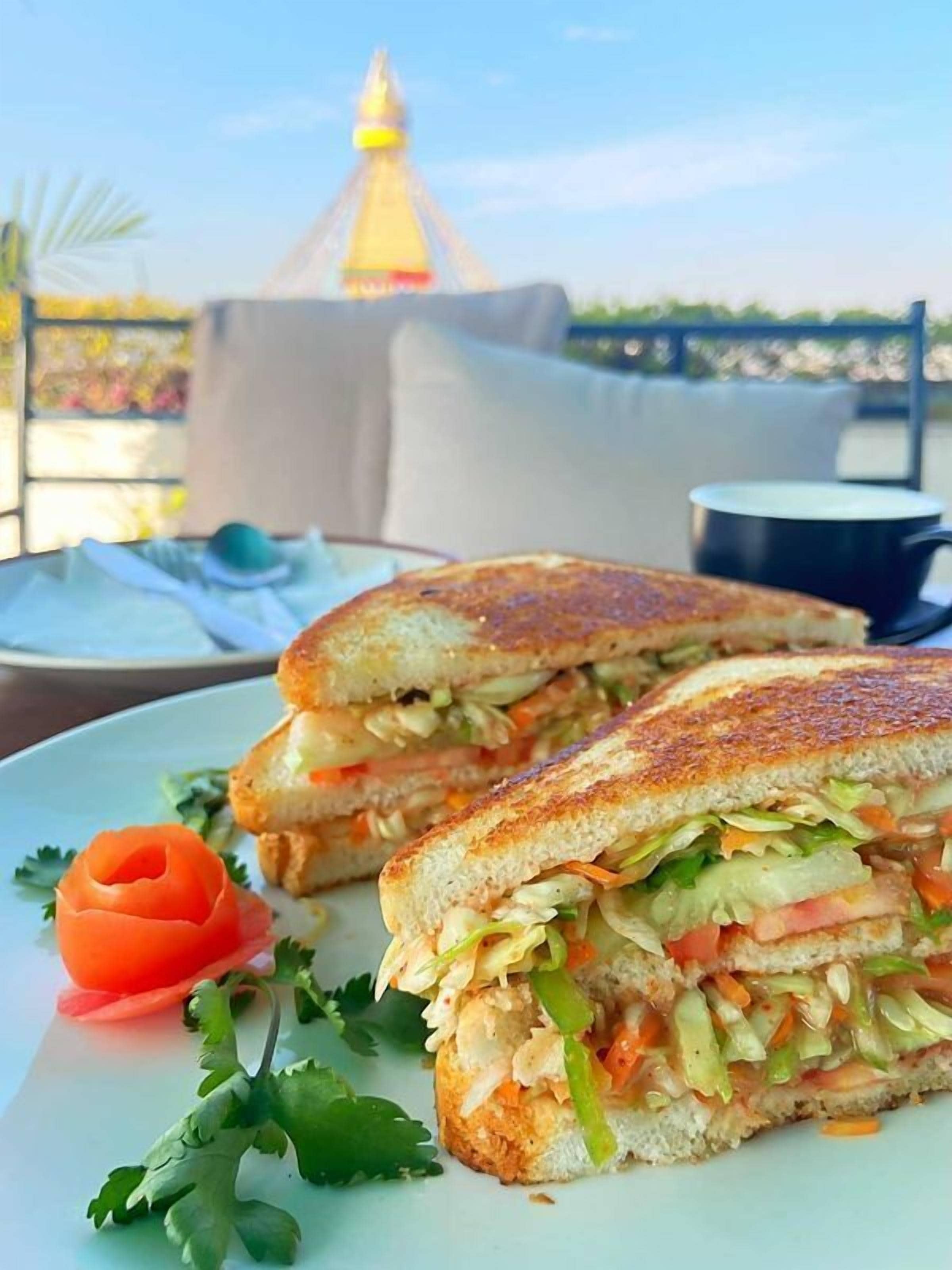 A sandwich on a plate with a view of a building in the background.