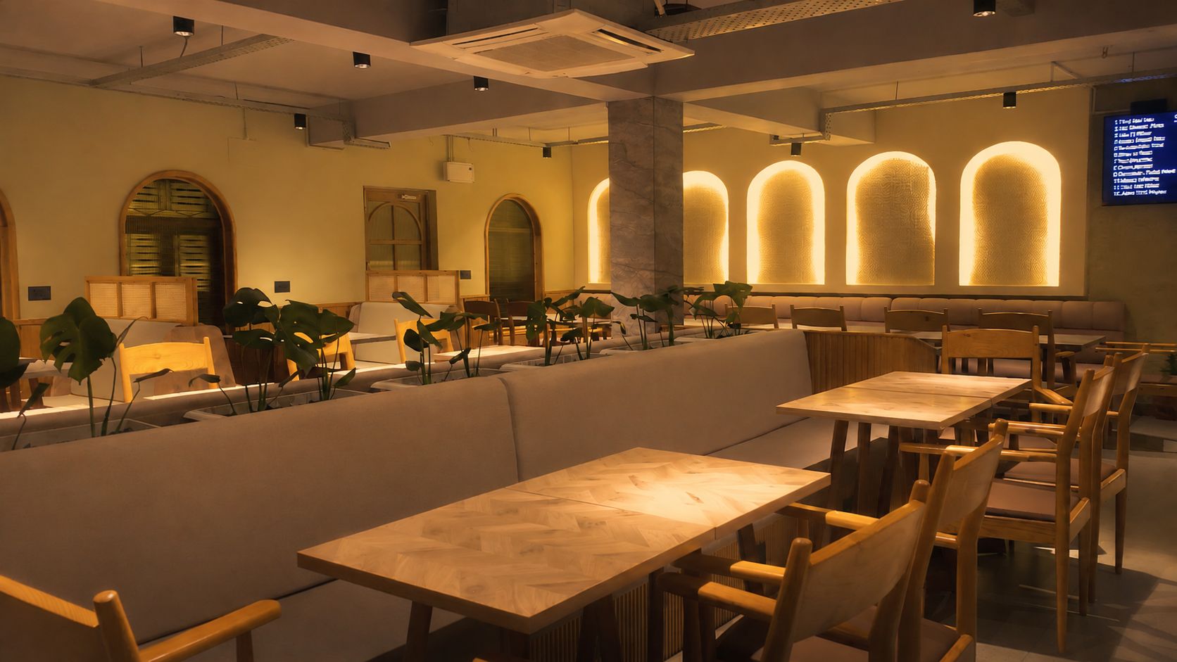 Un restaurante con mesas y sillas de madera, una barra larga y ventanas arqueadas.