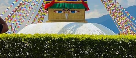 A traditional building with a pointed roof and colorful prayer flags.