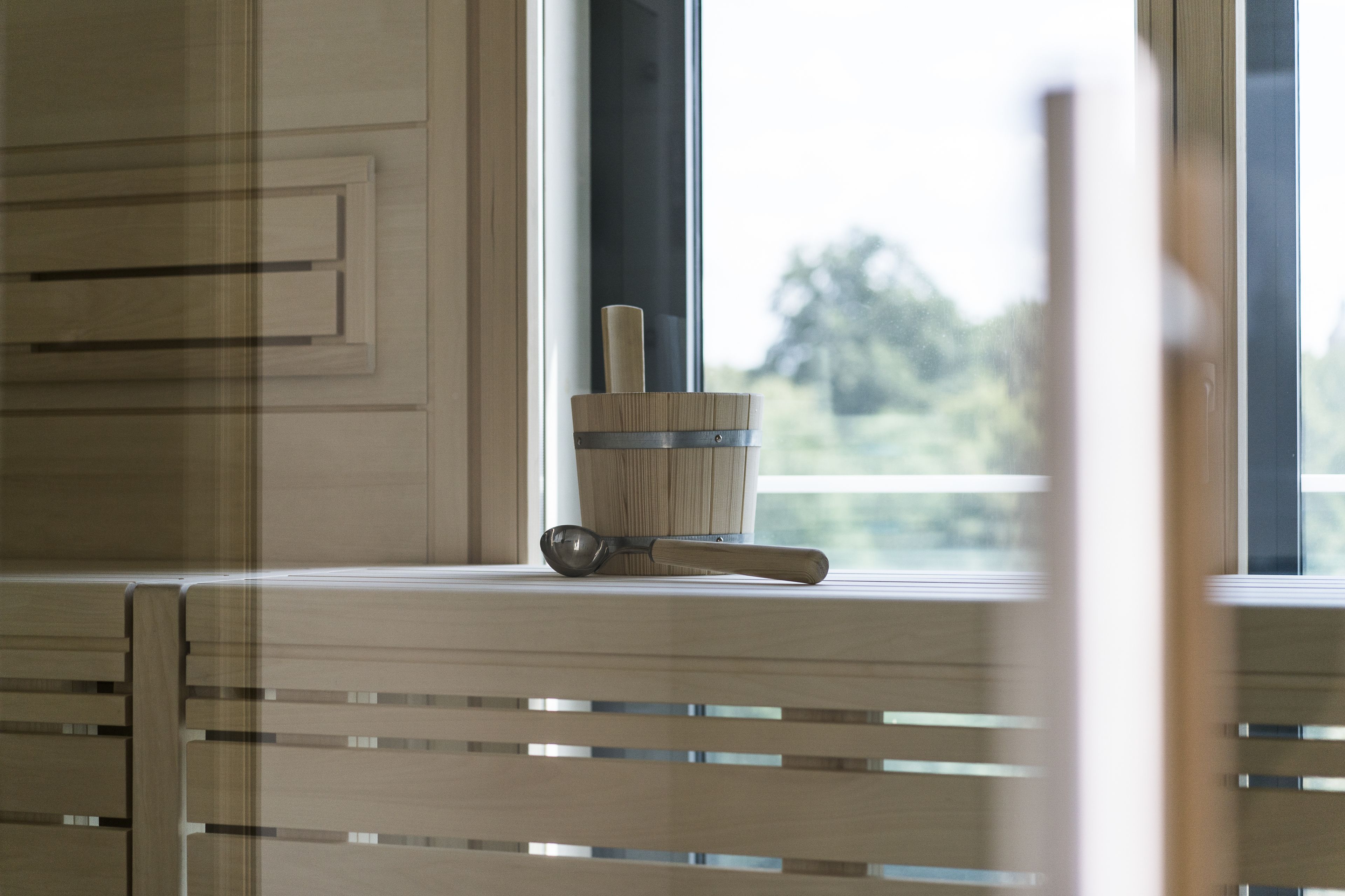 A kitchen counter with a wooden utensil holder and a metal spoon.