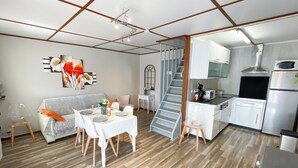 Un appartement moderne comprenant un coin repas, une cuisine et un escalier.
